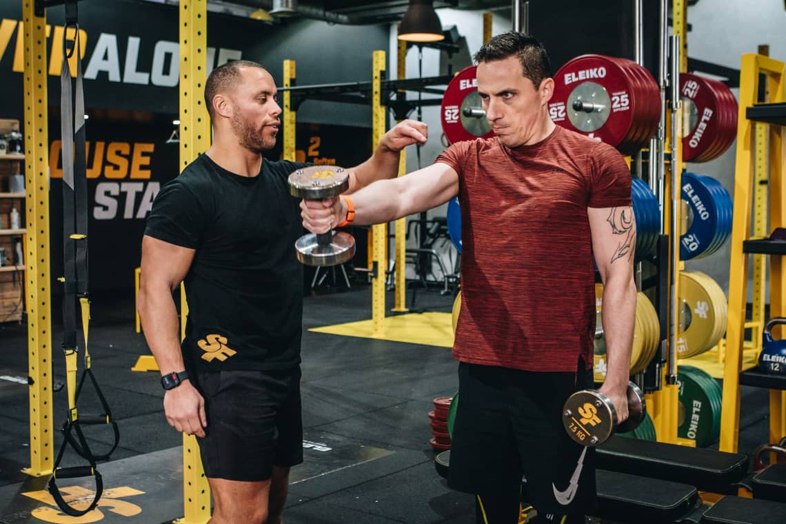 Lucas helping client with front raises