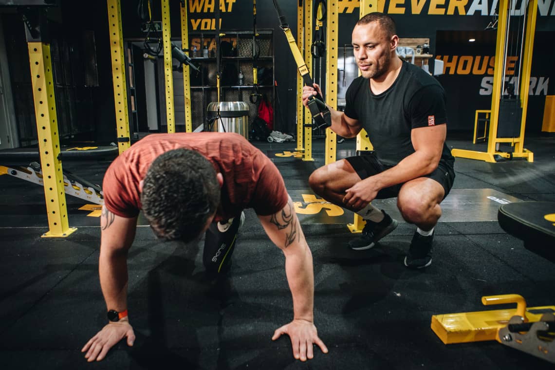 Lucas helping client with the TRX